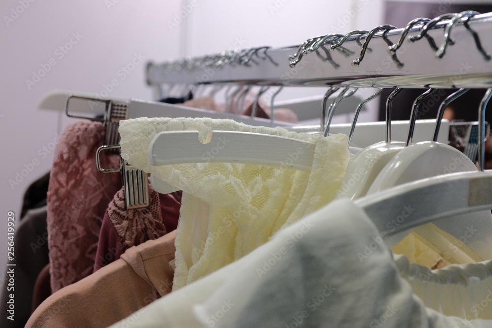 Feminine Garments hang on a rail on white hangers
