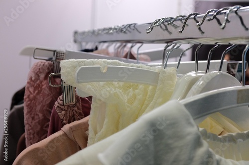 Obraz na płótnie Feminine Garments hang on a rail on white hangers w salonie