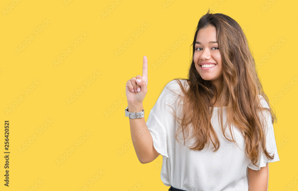 Young beautiful brunette business woman over isolated background pointing finger up with successful idea. Exited and happy. Number one. Young beautiful brunette business woman over isolated background pointing finger up with successful idea. Exited and happy. Number one.