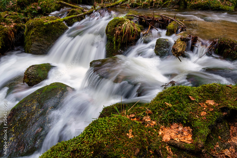 Wasserfall mit Steinen voller Moos Wasserfall mit Steinen voller Moos