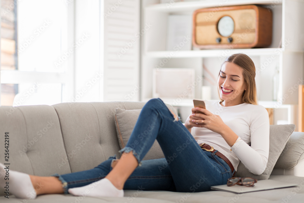 Young woman using her smartphone at home Young woman using her smartphone at home