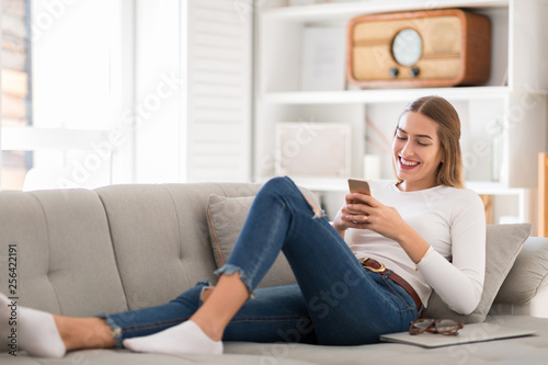 Free Download Young woman using her smartphone at home - GFXLoad