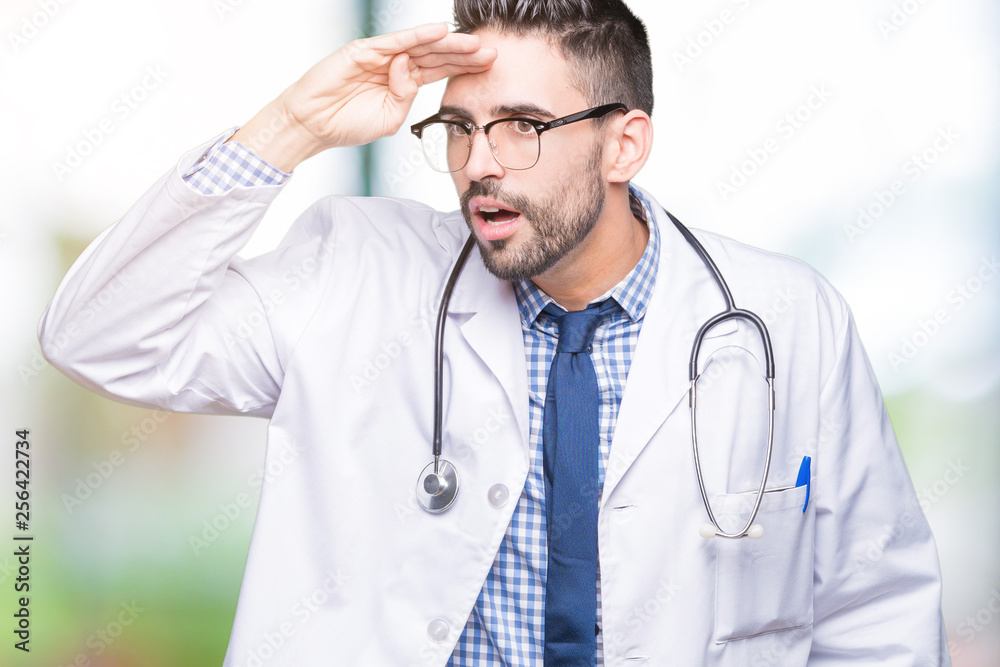 Handsome young doctor man over isolated background very happy and smiling looking far away with hand over head. Searching concept. Handsome young doctor man over isolated background very happy and smiling looking far away with hand over head. Searching concept.