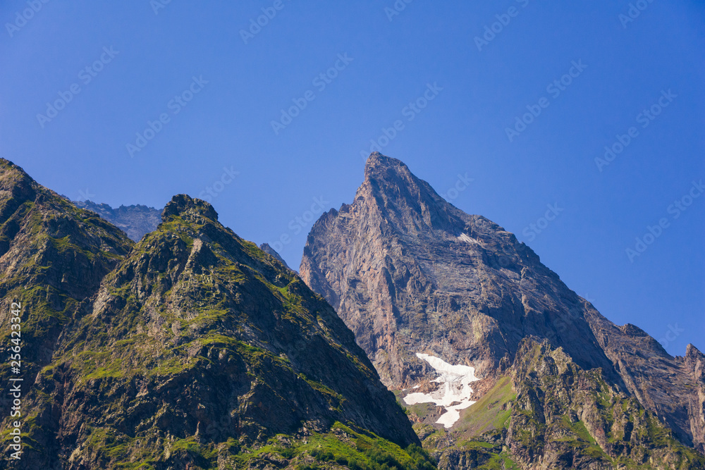 The tops of the mountains in the snow on a clear summer day. High in the Caucasian mountains, around dombai.