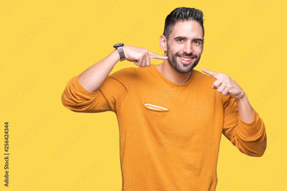 Young handsome man over isolated background smiling confident showing and pointing with fingers teeth and mouth. Health concept. Young handsome man over isolated background smiling confident showing and pointing with fingers teeth and mouth. Health concept.