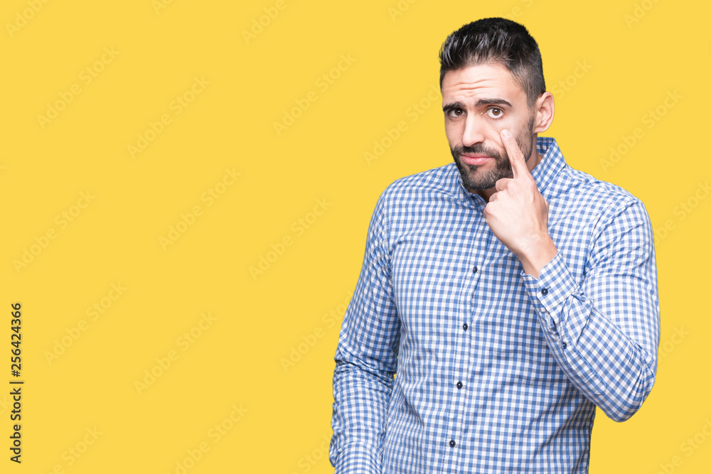 Young handsome man over isolated background Pointing to the eye watching you gesture, suspicious expression Young handsome man over isolated background Pointing to the eye watching you gesture, suspicious expression