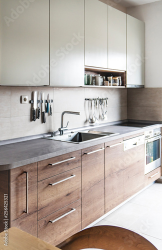 Luxury gray kitchen with wooden and stainless steel details and apliances. photo