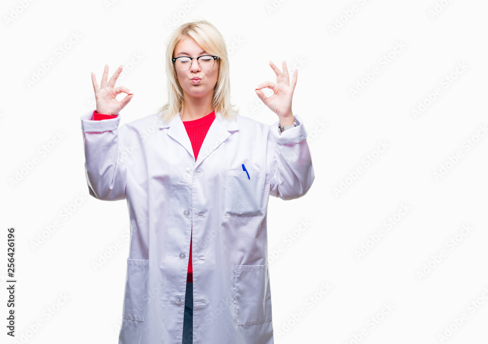 Young beautiful blonde professional woman wearing white coat over isolated background relax and smiling with eyes closed doing meditation gesture with fingers. Yoga concept.