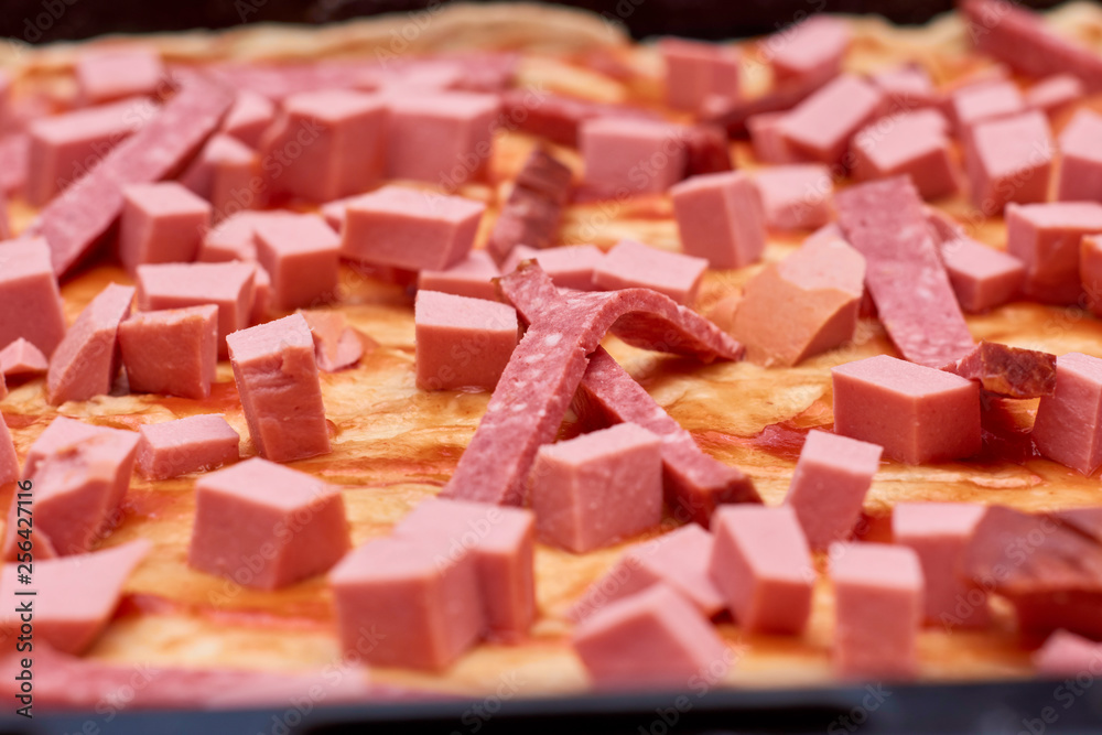 A variety of processed cold meat products, on a wooden cutting board