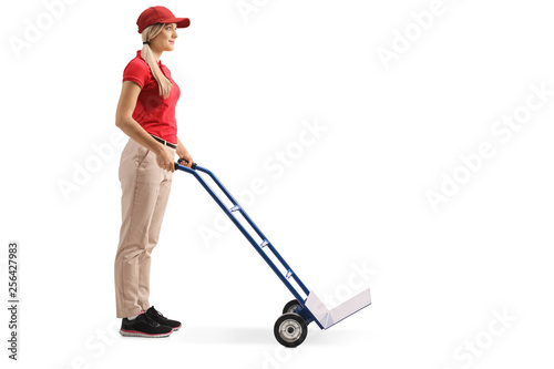 Female worker standing with an empty hand truck