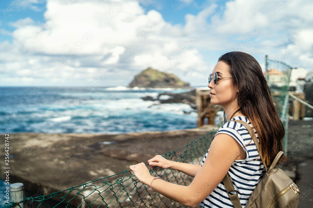 Pretty brunette girl walking outdoor near sea.