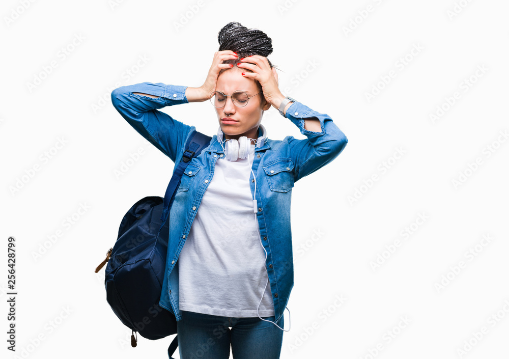 Young braided hair african american student girl wearing backpack over isolated background suffering from headache desperate and stressed because pain and migraine. Hands on head. Young braided hair african american student girl wearing backpack over isolated background suffering from headache desperate and stressed because pain and migraine. Hands on head.