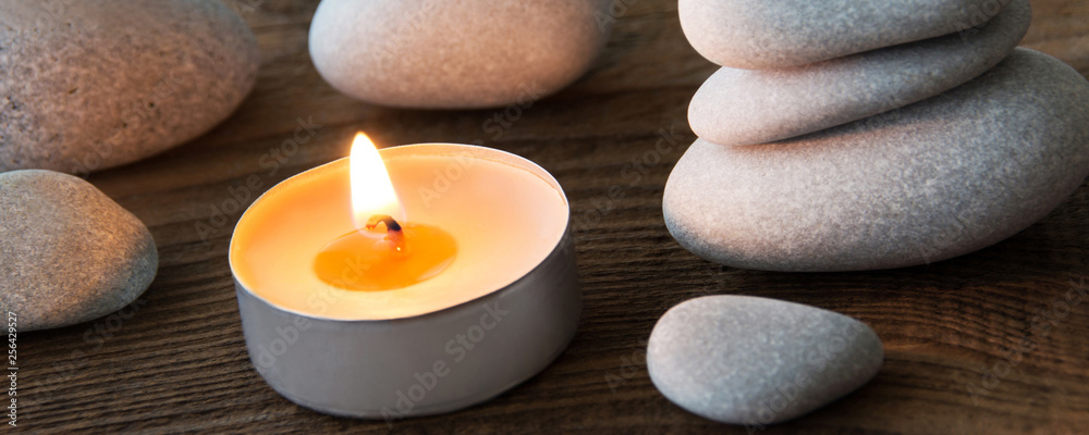 Stones and candle decoration against wooden background Stones and candle decoration against wooden background