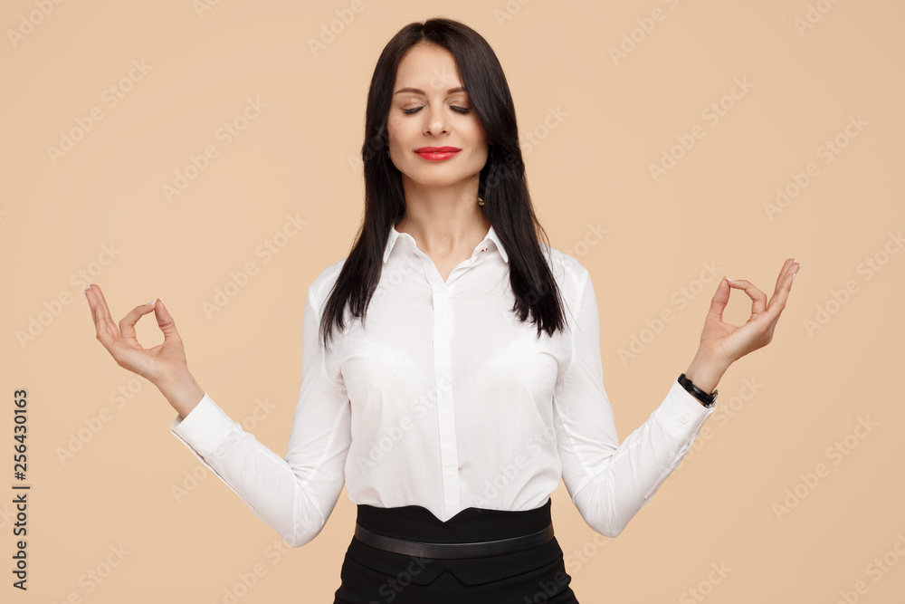 Happy young modern business woman meditating over beige background. Meditation, religion and spiritual practices. Happy young modern business woman meditating over beige background. Meditation, religion and spiritual practices.