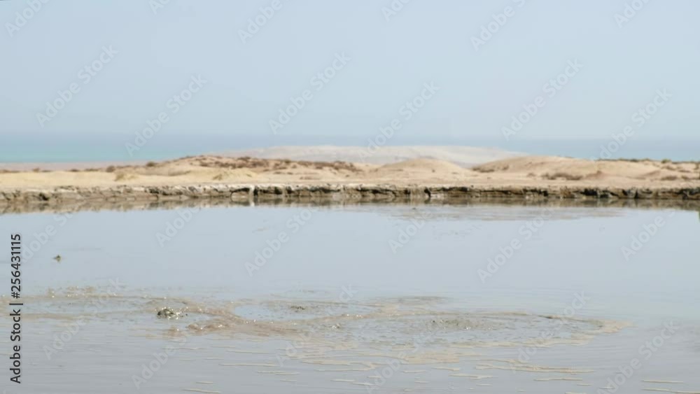 Crater of mud volcano bursting bubbles with natural gas. Famous nature landmark of Gobustan area near Baku in Azerbaijan Crater of mud volcano bursting bubbles with natural gas. Famous nature landmark of Gobustan area near Baku in Azerbaijan
