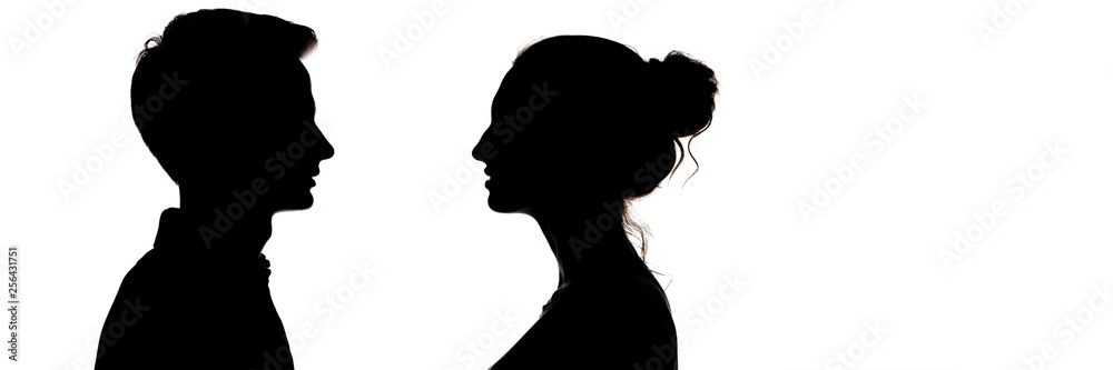 silhouetteof a guy and a girl looking at each other, head profile of teenagers in love, the concept of relationships and feelings on a white isolated background