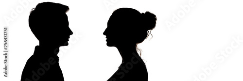 silhouetteof a guy and a girl looking at each other, head profile of teenagers in love, the concept of relationships and feelings on a white isolated background © Creatopic