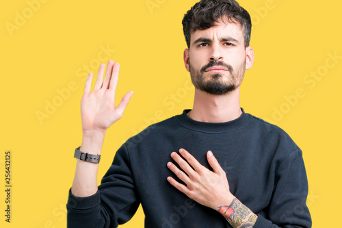 Young handsome man over isolated background Swearing with hand on chest and open palm, making a loyalty promise oath © Krakenimages.com
