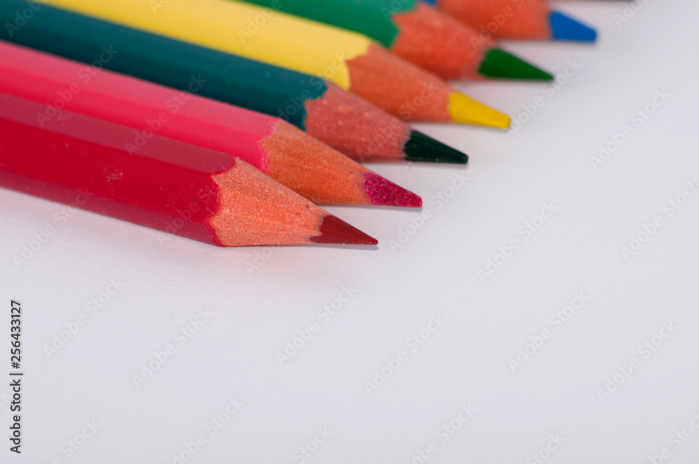 Color pencils on a white background close-up, macro, side view Color pencils on a white background close-up, macro, side view