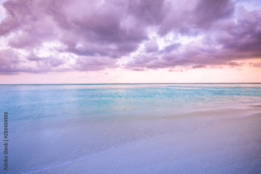 Obraz premium Beautiful morning, pink sunrise over sea, soft waves and calm sea under cloudy sky