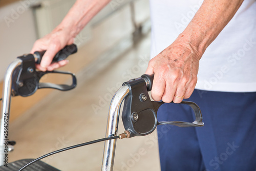 Ages senior man using walker indoor, detail on man's hands