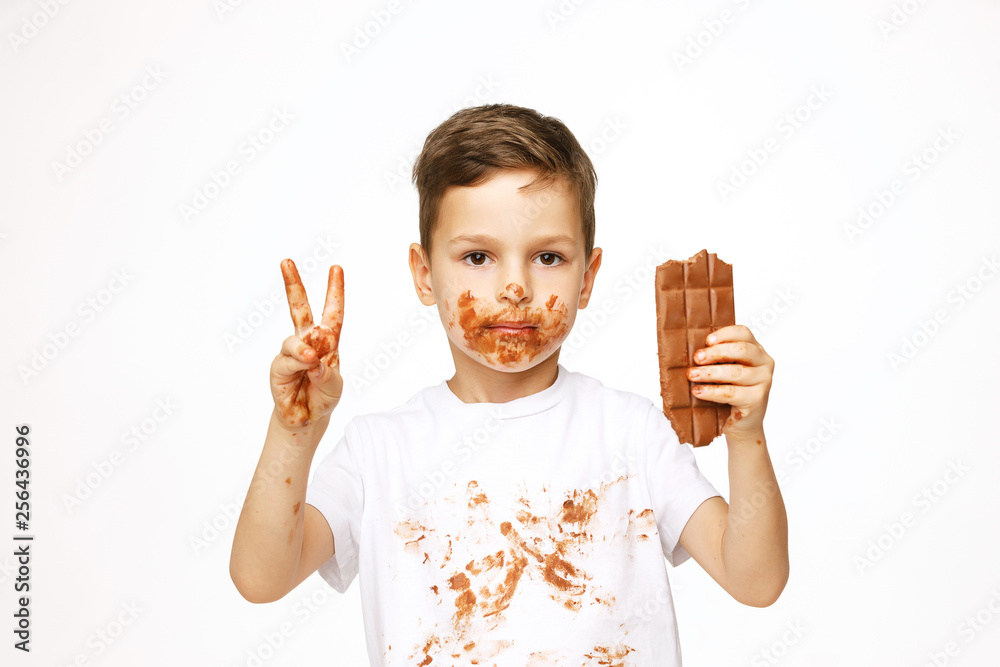 little boy with face and hands in chocolate little boy with face and hands in chocolate