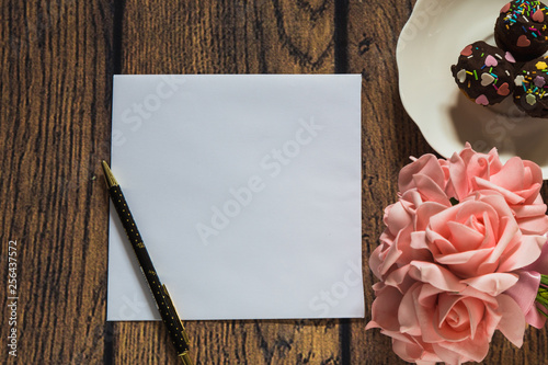 card with roses on wooden background