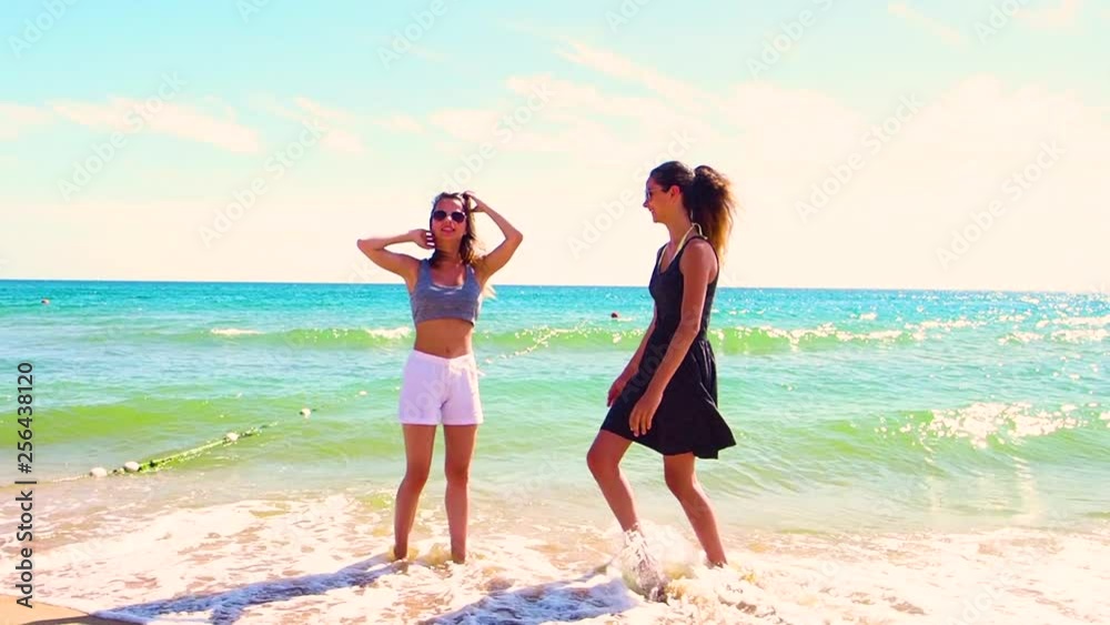 Two young women best friends brunettes cheerful girls having fun outdoor wind blowing in hair. Summer happiness friendship concept.slow motion Two young women best friends brunettes cheerful girls having fun outdoor wind blowing in hair. Summer happiness friendship concept.slow motion