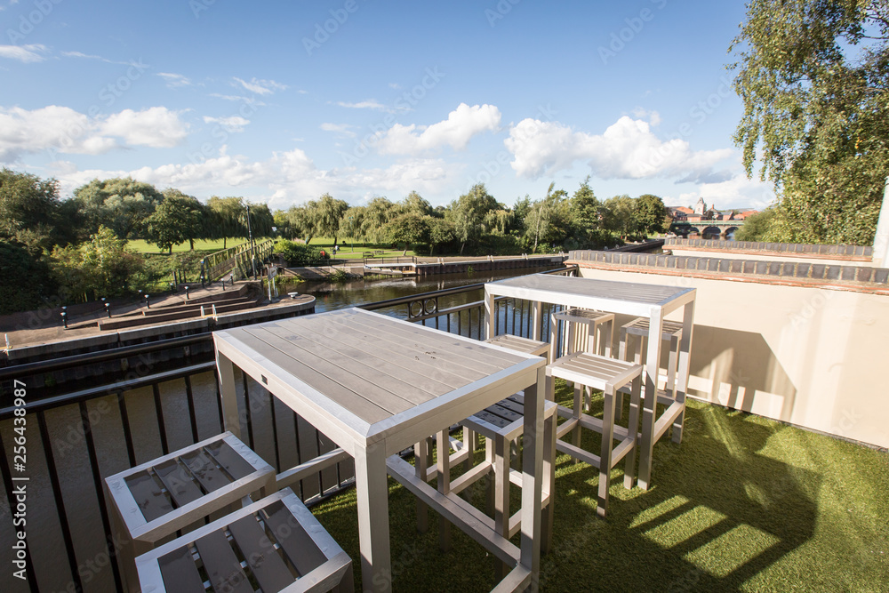 Fototapeta premium patio with table and chairs in garden overlooking river
