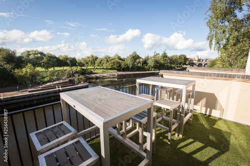 patio with table and chairs in garden overlooking river