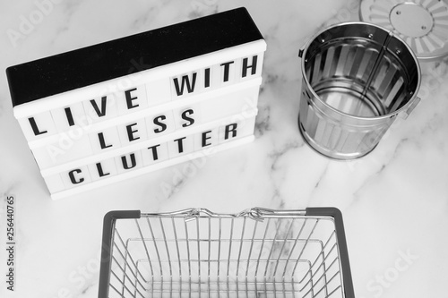Принти на полотні live with less clutter message on lightbox with shopping basket and trash bin