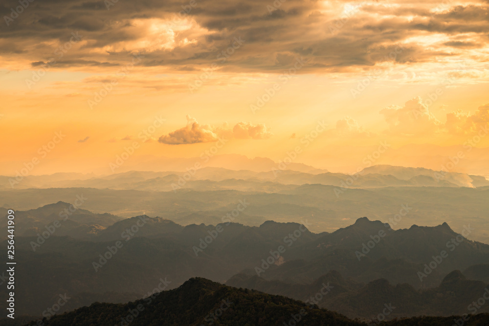 Orange sunset sky background. Sunset view from the top of mountain, Fog in the valley at sunset, Thailand. 