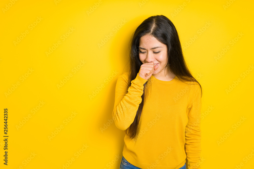 Beautiful brunette woman over yellow isolated background feeling unwell and coughing as symptom for cold or bronchitis. Healthcare concept. Beautiful brunette woman over yellow isolated background feeling unwell and coughing as symptom for cold or bronchitis. Healthcare concept.