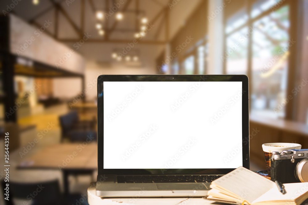 Mockup image of laptop with blank white screen with camera,notebook,coffee cup on wooden table of In the coffee shop background. Mockup image of laptop with blank white screen with camera,notebook,coffee cup on wooden table of In the coffee shop background.