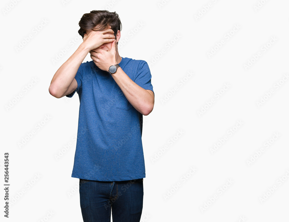 Young handsome man wearing blue t-shirt over isolated background Covering eyes and mouth with hands, surprised and shocked. Hiding emotion Young handsome man wearing blue t-shirt over isolated background Covering eyes and mouth with hands, surprised and shocked. Hiding emotion