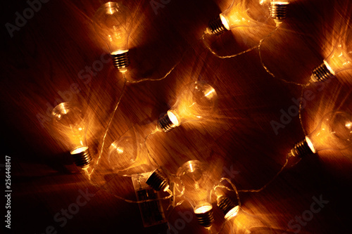 Garland of vintage bulb lamps with modern yellow LED lighting elements, close up photo