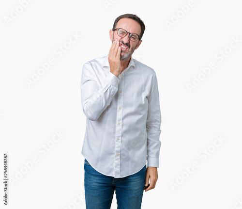 Handsome middle age elegant senior business man wearing glasses over isolated background touching mouth with hand with painful expression because of toothache or dental illness on teeth © Krakenimages.com