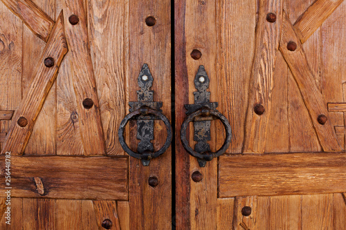 closed double wooden doors with round iron handles