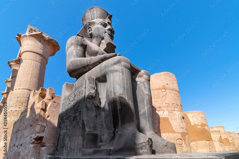 The huge statue of Ramesses II in Luxor Temple, Egypt, a large Ancient Egyptian temple complex located on the east bank of the Nile River in the city today known as Luxor (ancient Thebes).