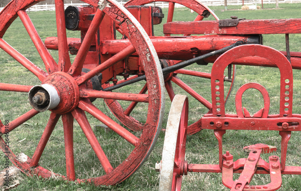 Red wooden wheels and vintage farm machinery