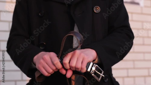Belt in the hands of a man before punishing a child
