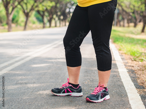 Overweight woman standing in the park before running. Weight loss concept