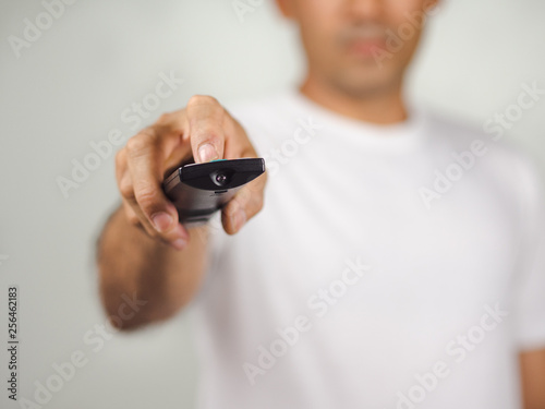 Closeup of a man pess the remote controller button on white background photo