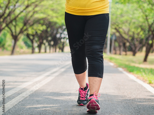 Overweight woman running in the park. Weight loss concept