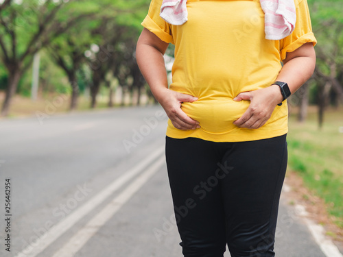 Overweight woman holding her belly. Weight loss concept