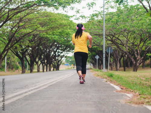 Overweight woman running in the park. Weight loss concept