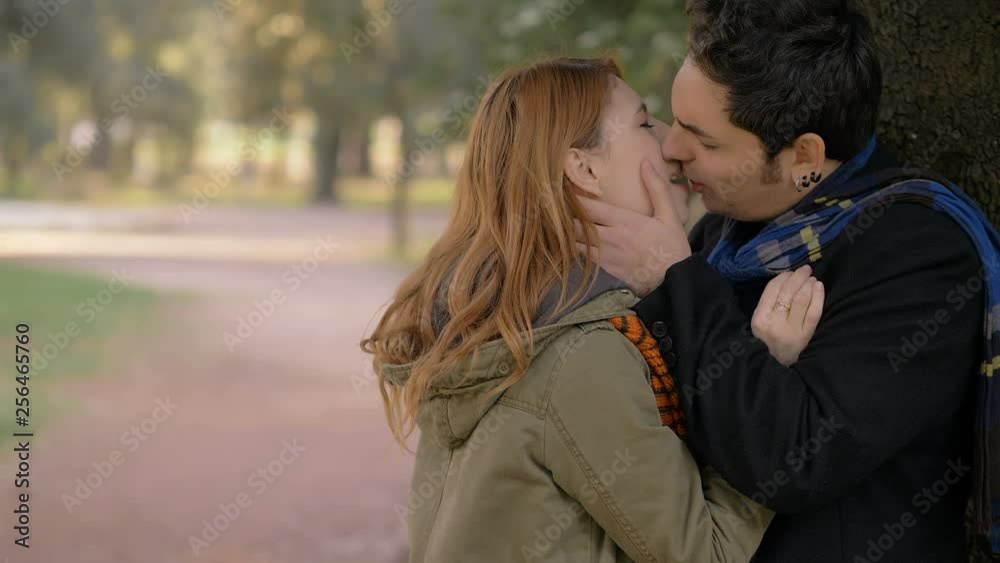 Infedelity scene. woman discovering her husband kissing other woman in the park Infedelity scene. woman discovering her husband kissing other woman in the park