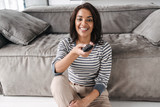 Attractive young afro american woman sitting on a couch