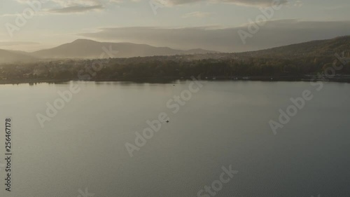 Wallpaper Mural Aerial drone shot of lonely boat on huge lake at sunset with mountains in background Torontodigital.ca