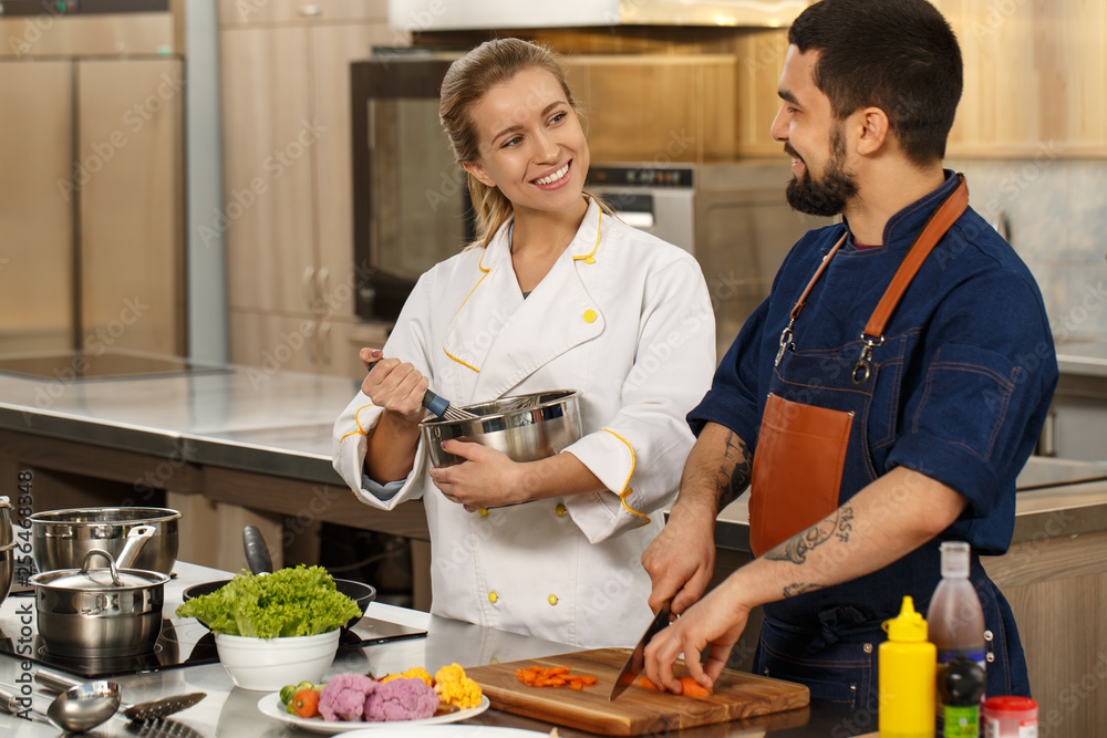 Professional chef and his assistant at the kitchen Professional chef and his assistant at the kitchen